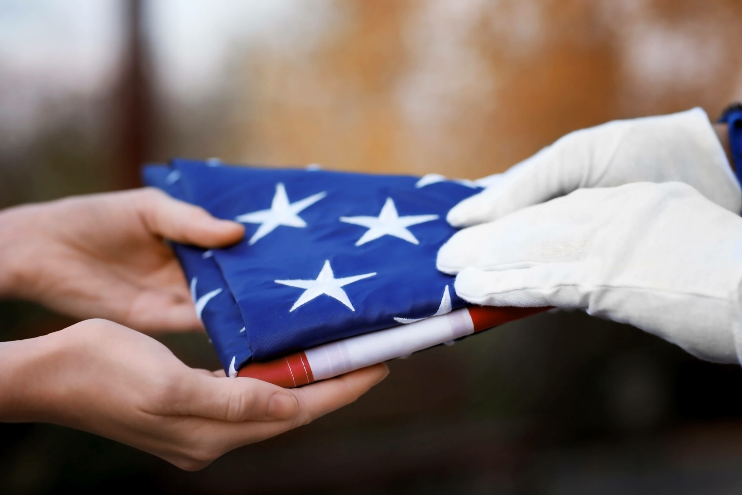 folded american flag being handed over